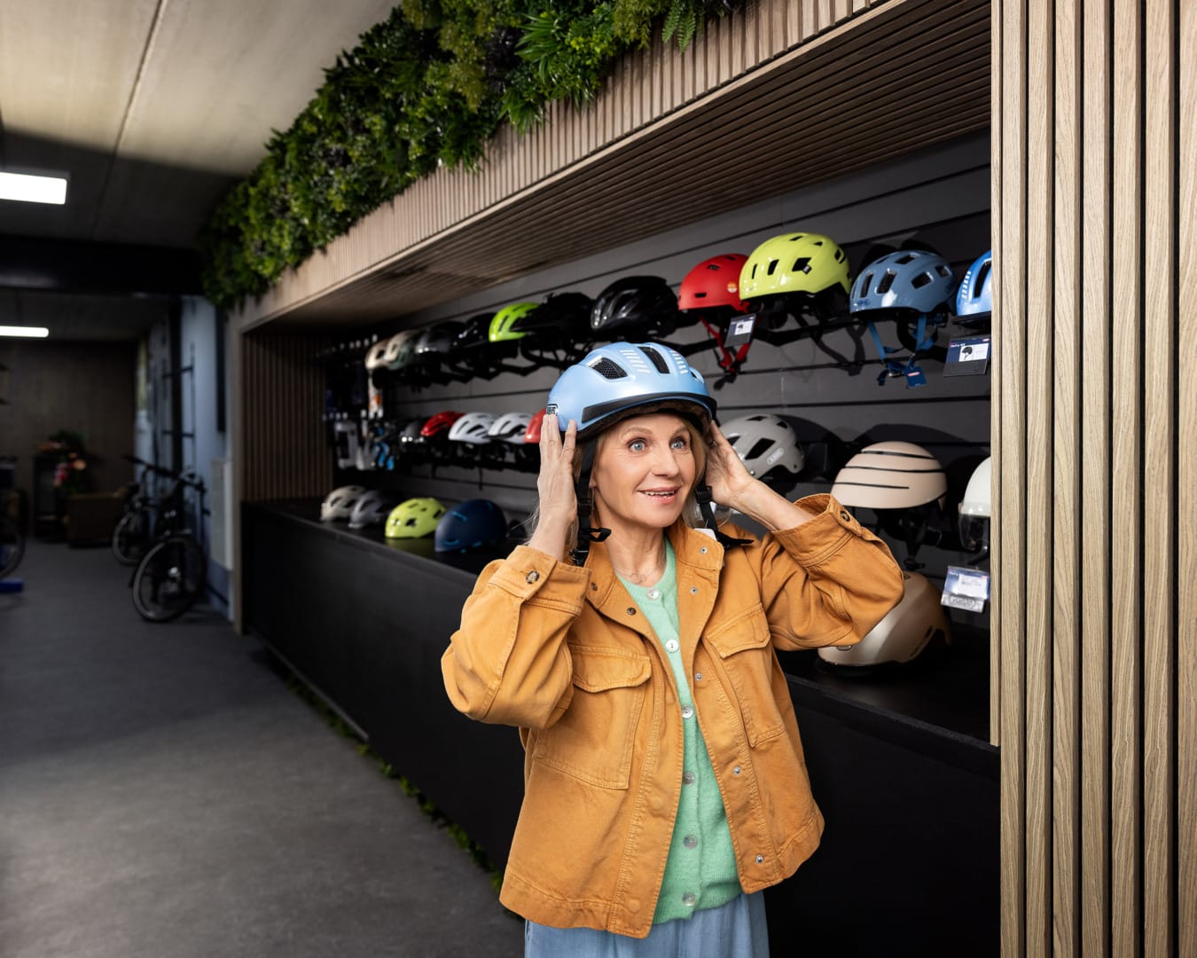 Vrouw past fietshelm in fietsenzaak voor campagne Vervoerregio Amsterdam