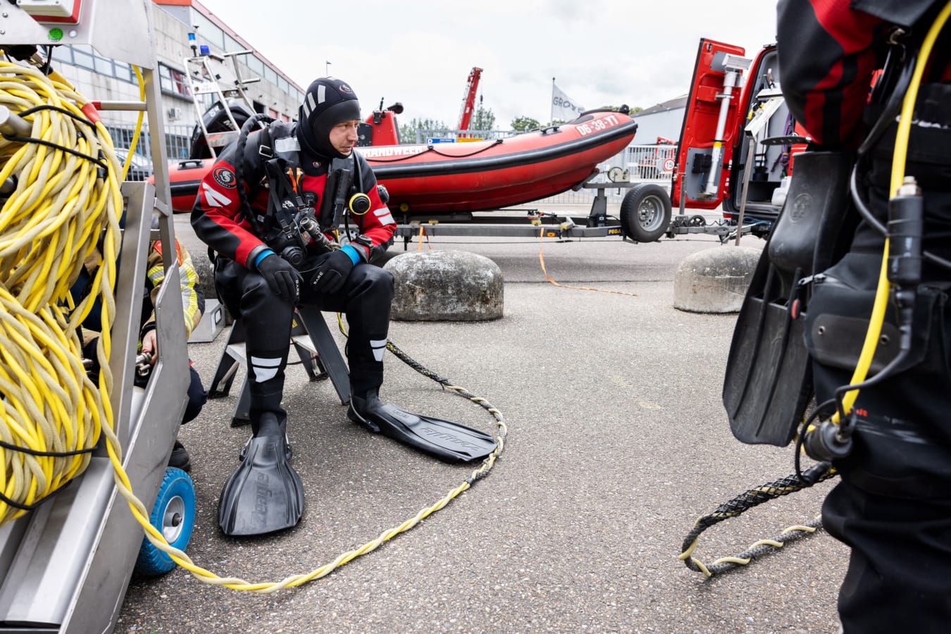 Duiker wacht zittend bij boot
