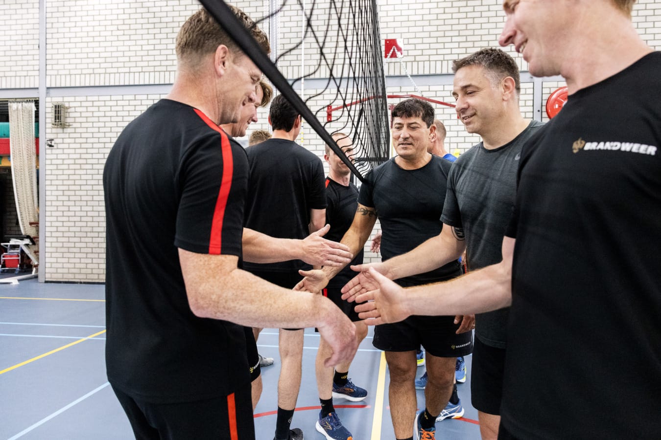 Brandweermannen high-fiven na potje volleybal