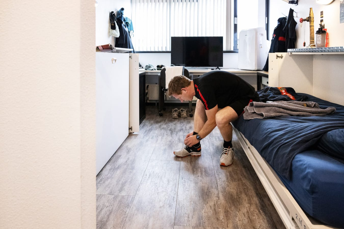 Brandweerman strikt schoenen in zijn kamer