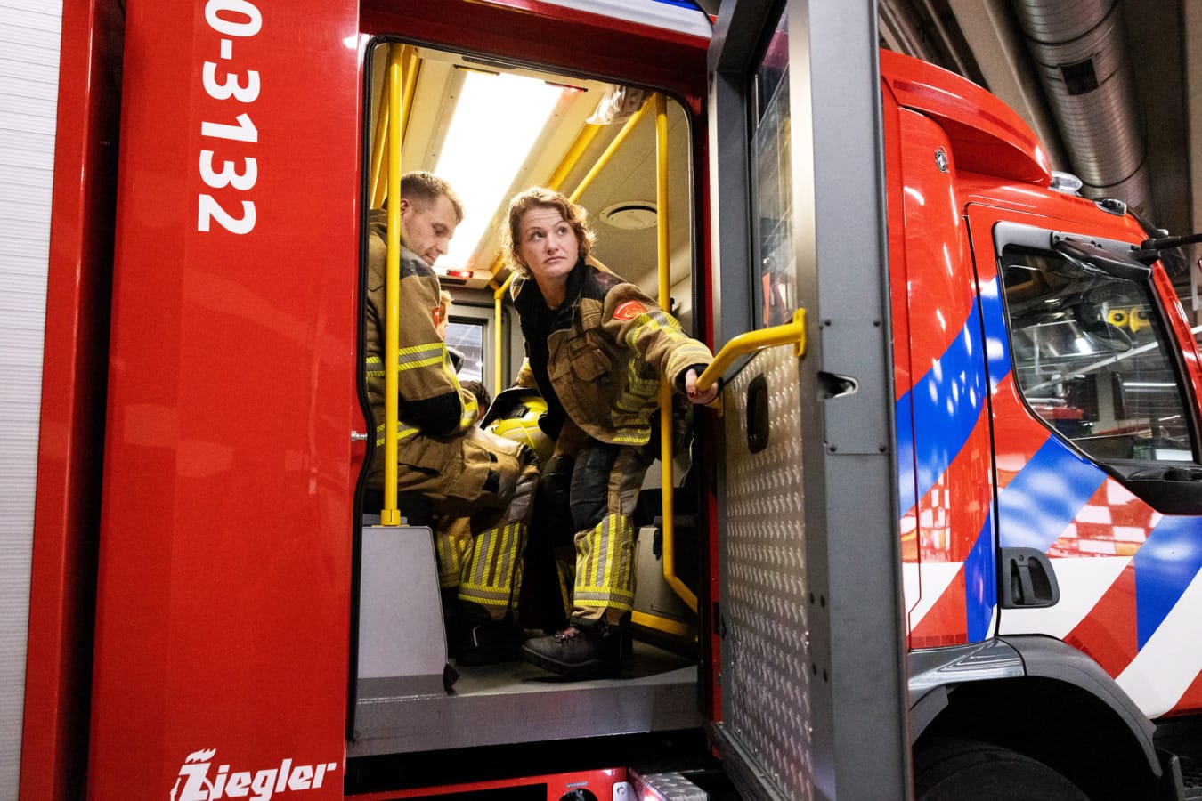 Brandweervrouw sluit deur in Brandweerwagen