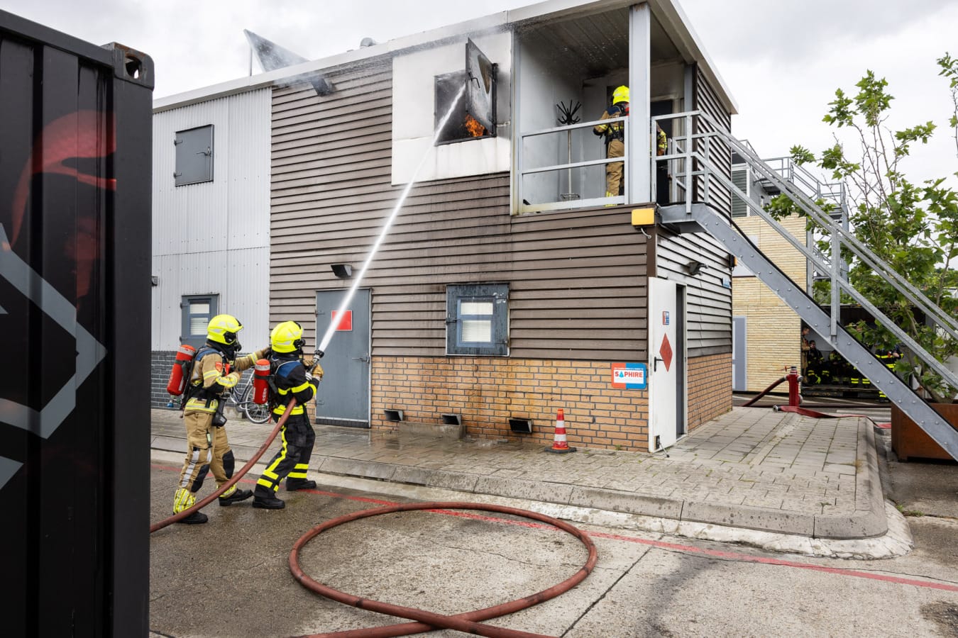 Brandweermannen blussen brand bij oefening