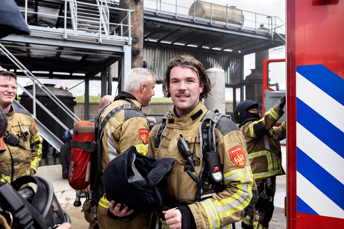 Brandweerman met helm in handen na oefening