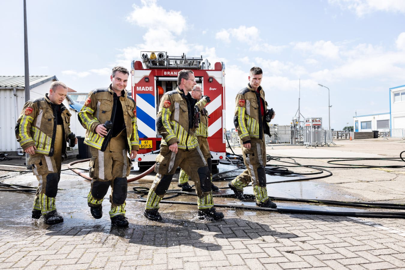 Groep brandweermannen lopen na oefening