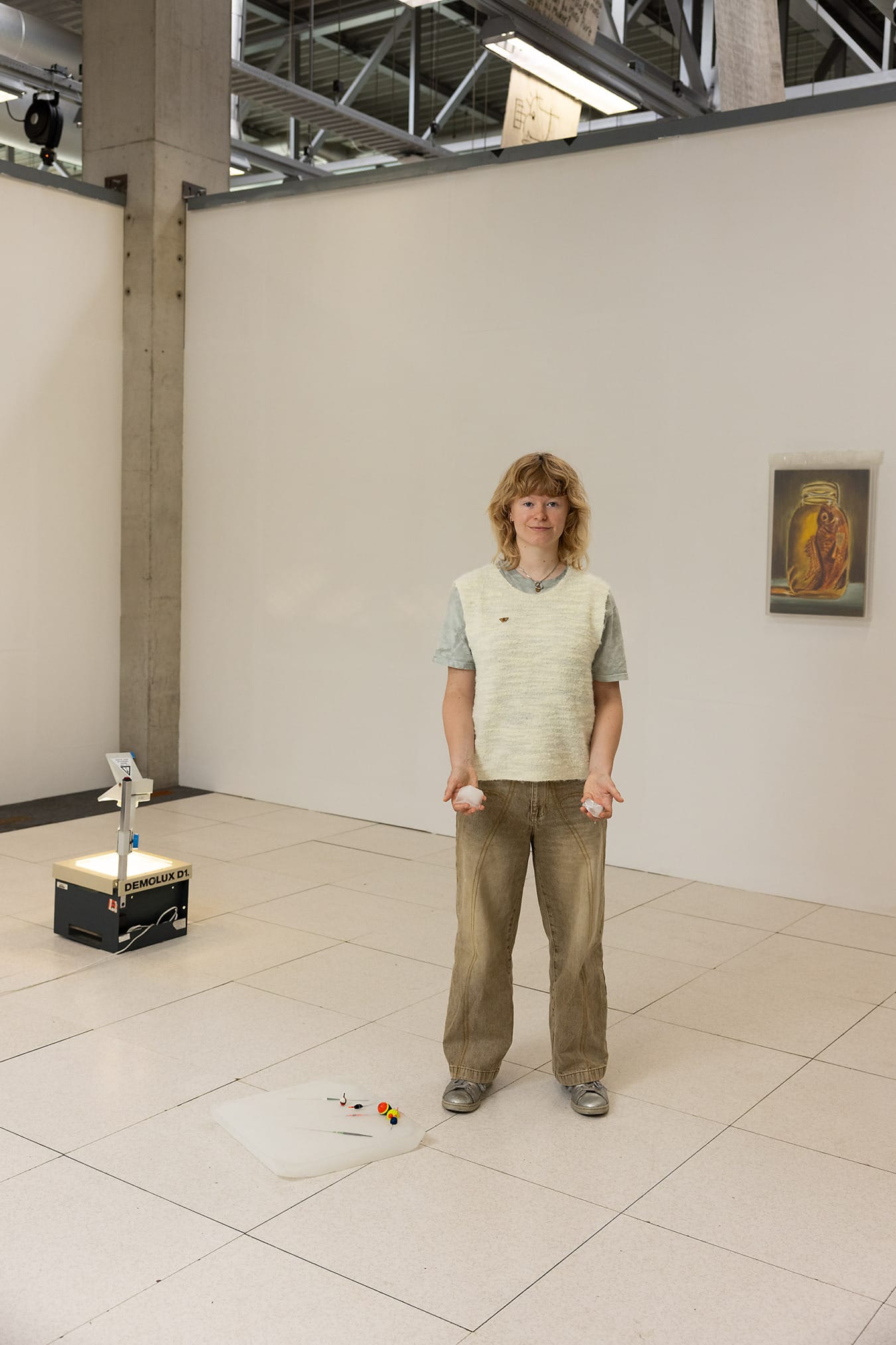 Student kunstacademie met ijs in haar handen staand bij haar werk