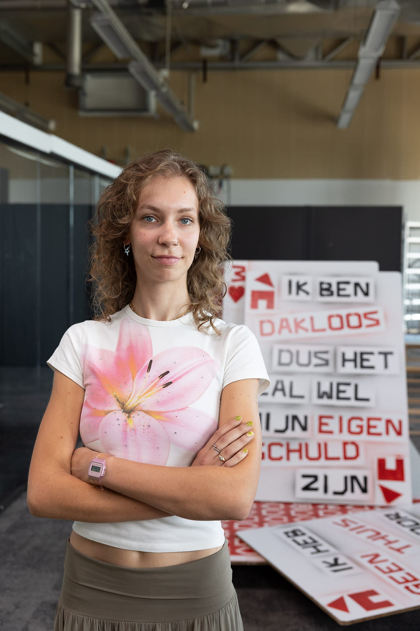 Student kunstacademie met armen gekruist voor haar werk