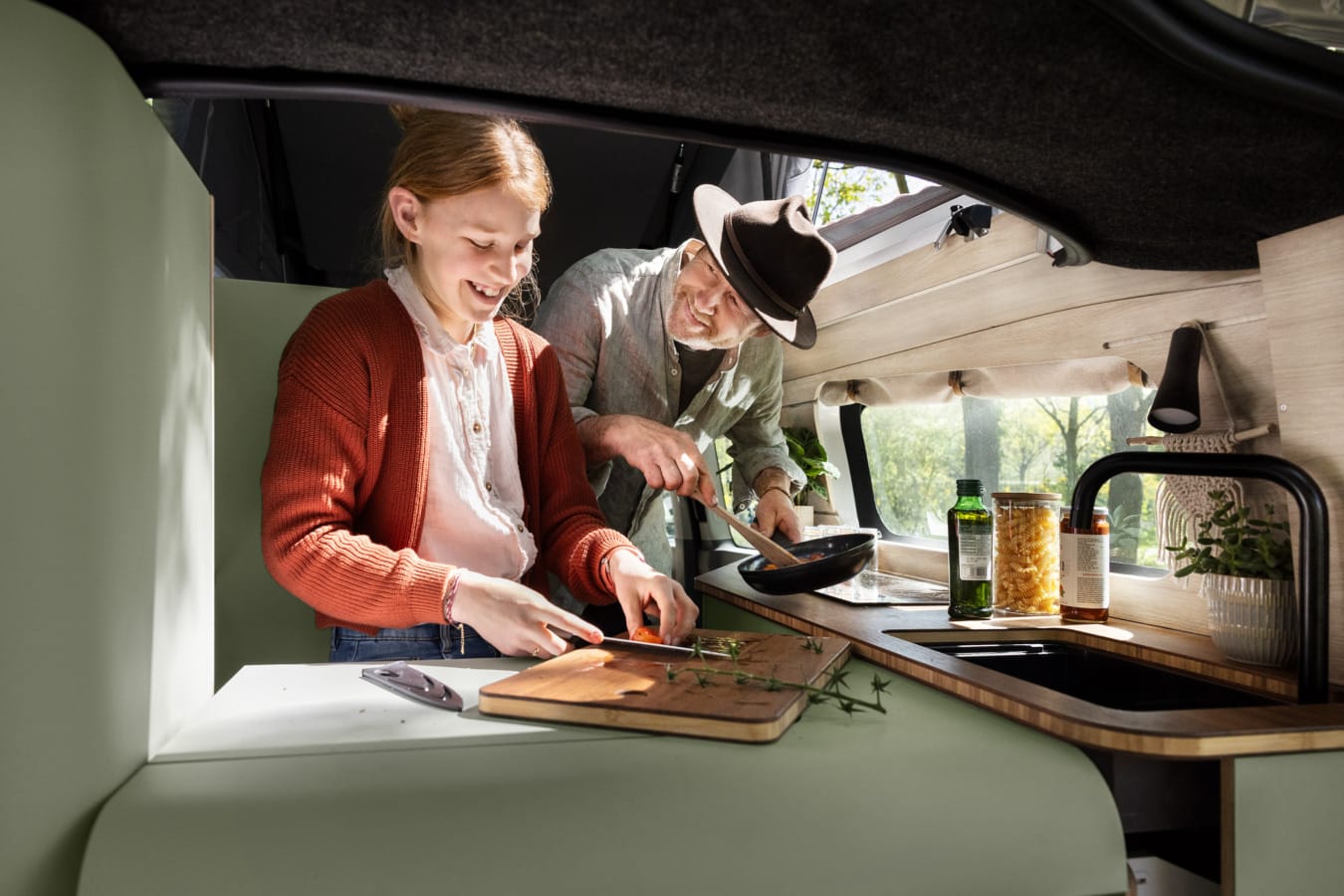 Vader en dochter koken in camper
